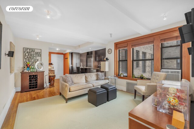 living room featuring wood-type flooring, cooling unit, and beam ceiling