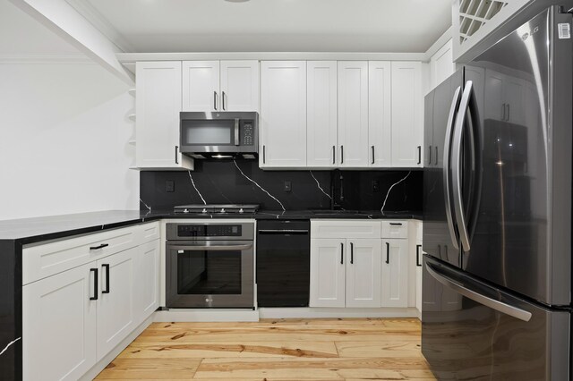 kitchen with stainless steel appliances, dark countertops, a sink, and open shelves