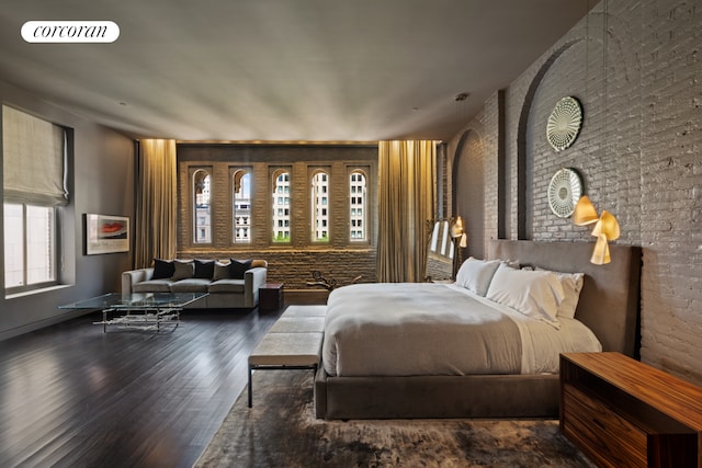 bedroom with visible vents, brick wall, and wood finished floors