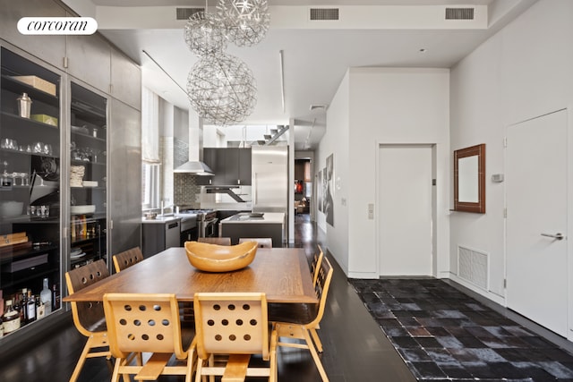 dining space featuring an inviting chandelier, dark wood-type flooring, built in features, and vaulted ceiling with skylight