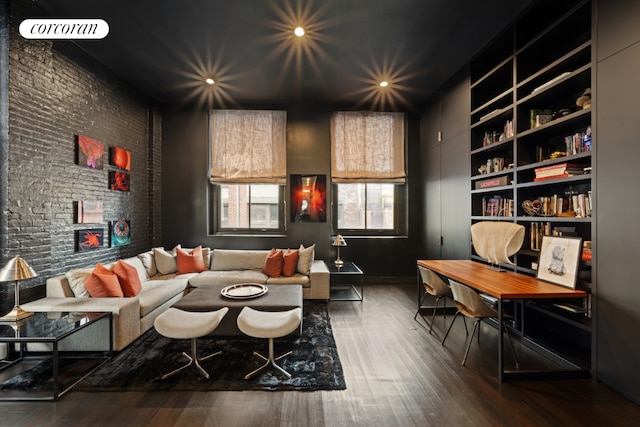 bedroom with hardwood / wood-style flooring and brick wall