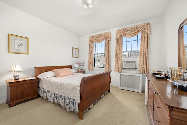 bedroom featuring cooling unit, radiator, and light colored carpet