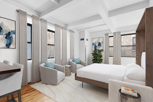 bedroom featuring beamed ceiling and light hardwood / wood-style floors