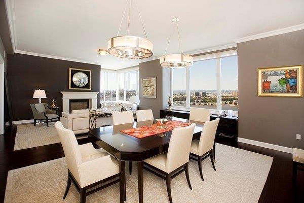 dining space featuring a fireplace, baseboards, crown molding, and wood finished floors