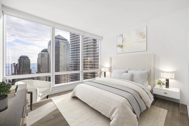 bedroom with a city view and wood finished floors