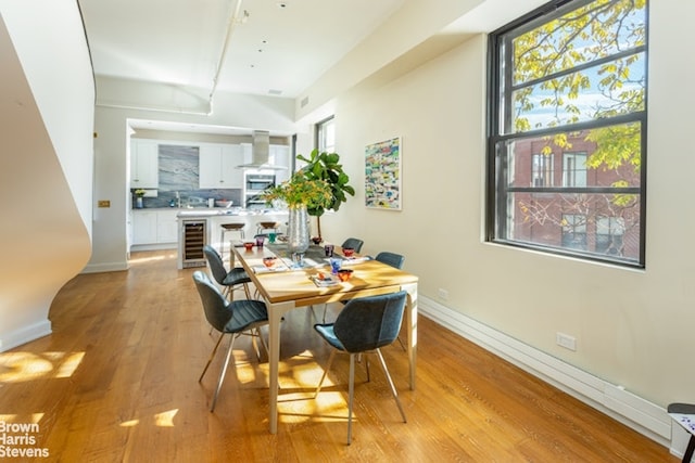 dining room with beverage cooler and light wood-type flooring