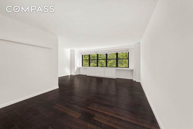 empty room with hardwood / wood-style flooring and baseboards