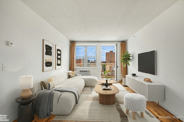 bedroom with access to exterior, wood-type flooring, and a wall unit AC