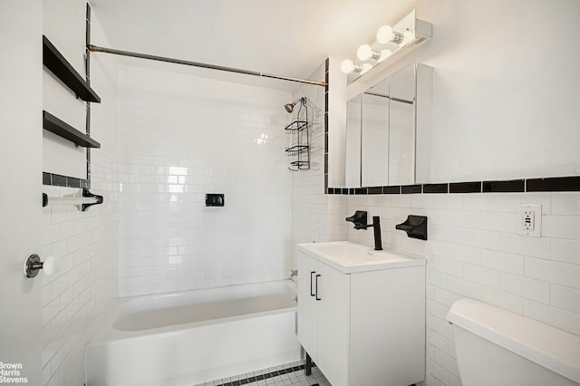 full bathroom featuring vanity, shower / tub combination, toilet, and tile walls