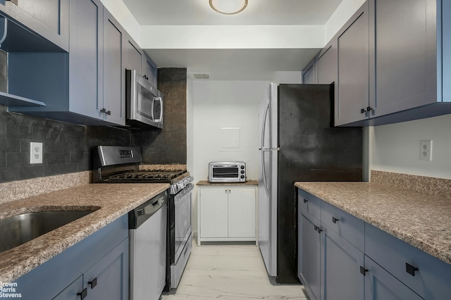 kitchen featuring marble finish floor, a toaster, tasteful backsplash, visible vents, and appliances with stainless steel finishes