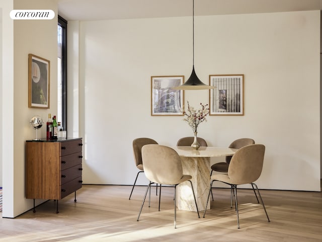 dining area with a wall of windows, visible vents, and light wood finished floors