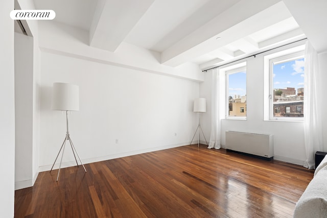 unfurnished room with beamed ceiling, visible vents, hardwood / wood-style floors, radiator heating unit, and baseboards