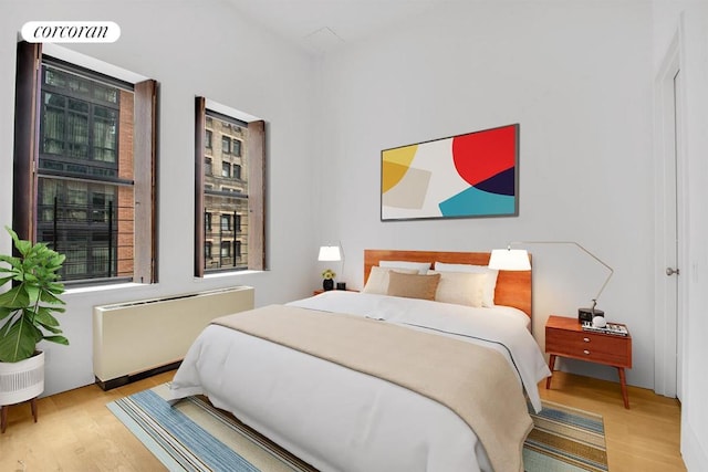 bedroom featuring light hardwood / wood-style floors and radiator heating unit