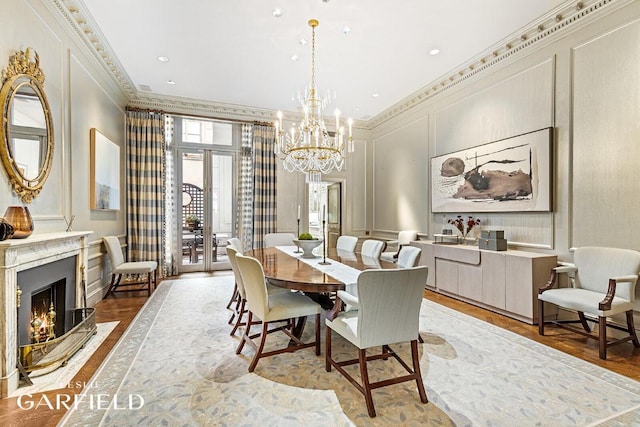 dining room with french doors, crown molding, an inviting chandelier, wood-type flooring, and a fireplace