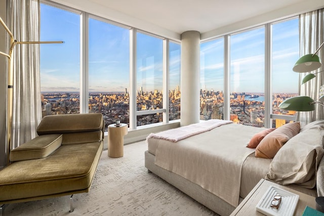 bedroom with light carpet and a wall of windows