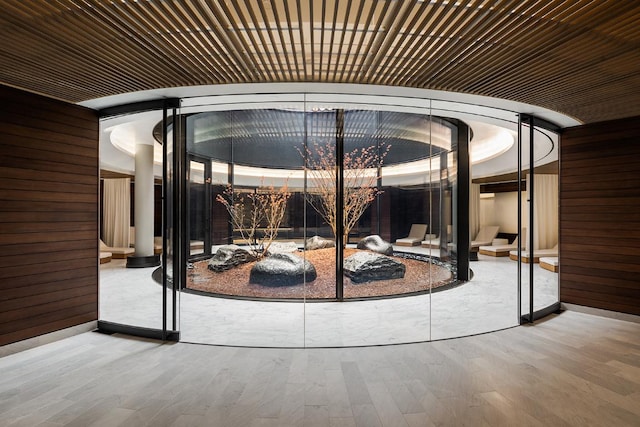 doorway to outside featuring hardwood / wood-style flooring, wooden ceiling, and wooden walls