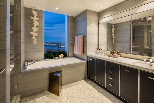 bathroom featuring vanity, tile patterned floors, plus walk in shower, and tile walls