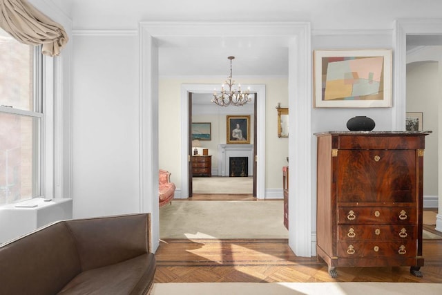 corridor featuring light parquet flooring, a wealth of natural light, crown molding, and a notable chandelier