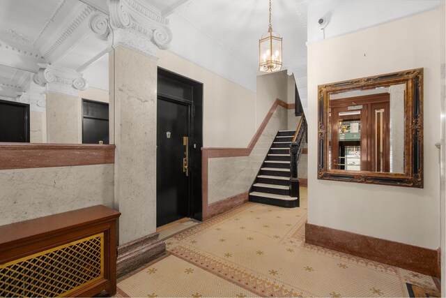 interior space featuring a notable chandelier, tile walls, and stairs