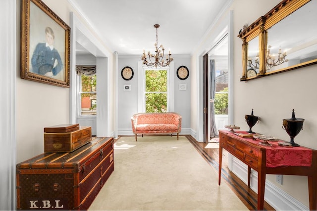 living area featuring crown molding, carpet floors, and a notable chandelier