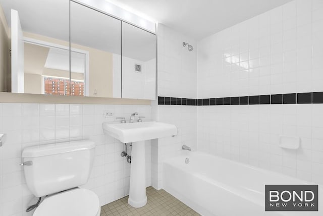 bathroom with shower / washtub combination, tile walls, visible vents, toilet, and tile patterned flooring