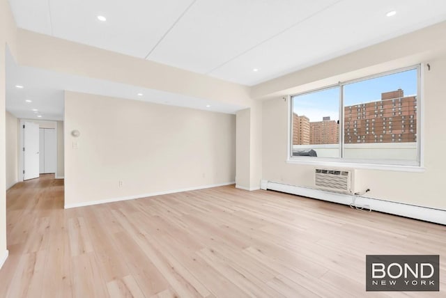 unfurnished living room with a wall mounted air conditioner, a baseboard radiator, and light hardwood / wood-style floors