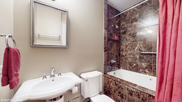 full bathroom featuring sink, shower / bath combo with shower curtain, and toilet