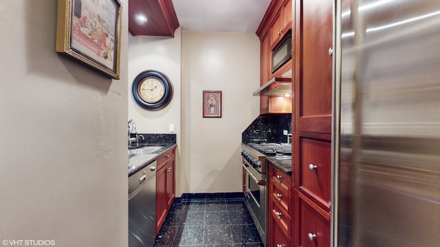 kitchen with decorative backsplash, sink, stainless steel appliances, and dark stone countertops