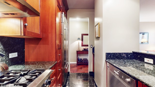 kitchen with dishwasher, dark stone countertops, and under cabinet range hood