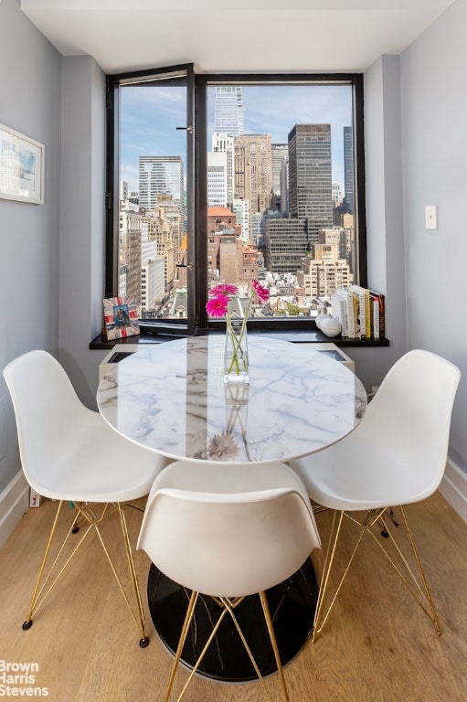 dining area featuring hardwood / wood-style floors, plenty of natural light, and a wall of windows