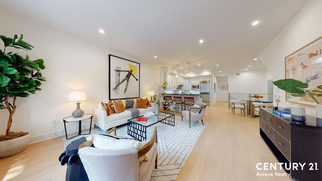 living room with light wood-style floors, recessed lighting, and baseboards