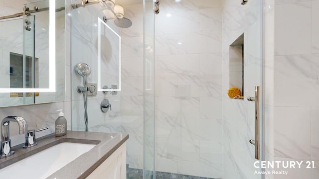 bathroom with a marble finish shower and vanity