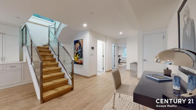 home office featuring light wood-style floors, a skylight, baseboards, and recessed lighting