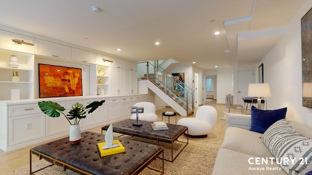 living area with light wood-type flooring, recessed lighting, built in features, and stairs