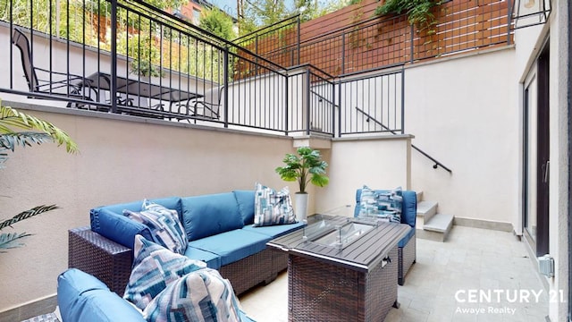 view of patio with an outdoor living space with a fire pit