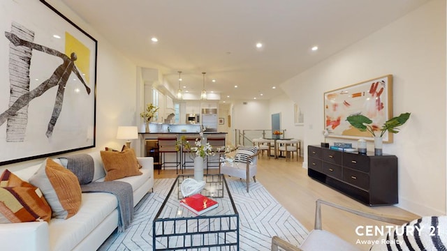 living area with light wood-style flooring and recessed lighting