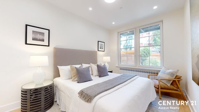 bedroom featuring radiator and hardwood / wood-style floors