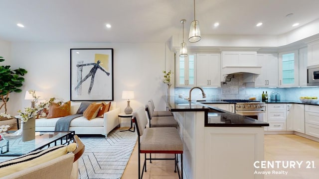 kitchen with appliances with stainless steel finishes, dark countertops, a kitchen bar, and glass insert cabinets