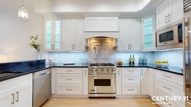 kitchen featuring dark countertops, appliances with stainless steel finishes, and white cabinets