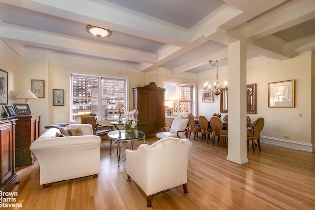 living room with light wood-type flooring, a notable chandelier, and beamed ceiling