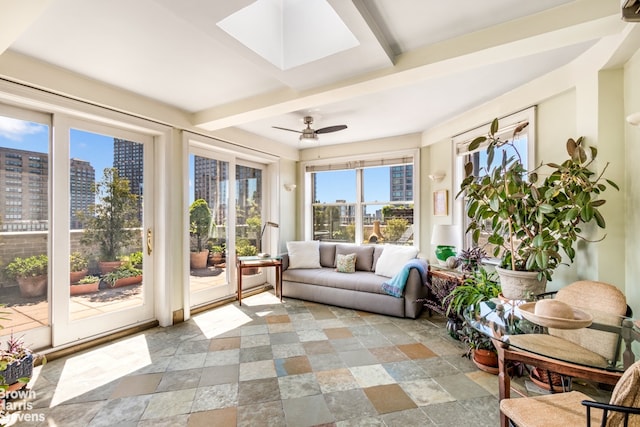 sunroom / solarium with ceiling fan, a skylight, and beamed ceiling