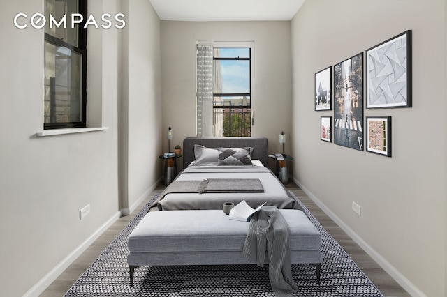 bedroom with baseboards and wood finished floors