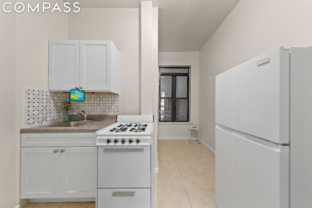 kitchen with sink, white cabinetry, light tile patterned floors, white appliances, and backsplash