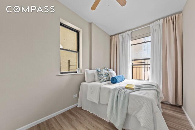 bedroom featuring baseboards, wood finished floors, and a ceiling fan