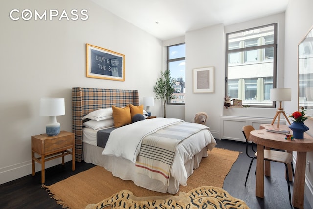 bedroom with baseboards and wood finished floors