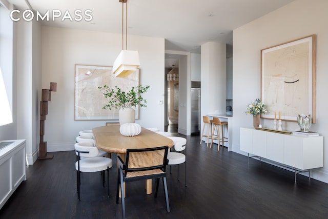 dining area with dark wood-style flooring and baseboards