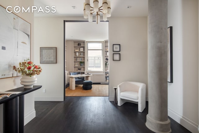 corridor with a chandelier, baseboards, and dark wood-type flooring