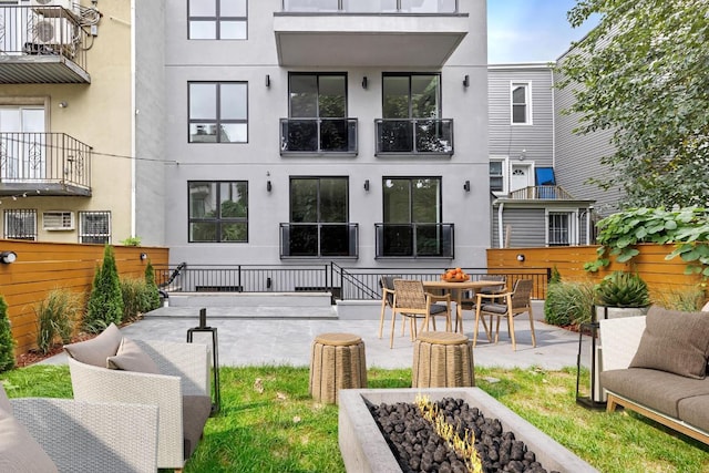 back of property with a wall mounted air conditioner and a patio area