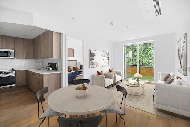 dining area featuring sink and light hardwood / wood-style flooring