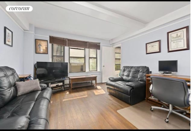 living room featuring beamed ceiling, cooling unit, and light wood-type flooring